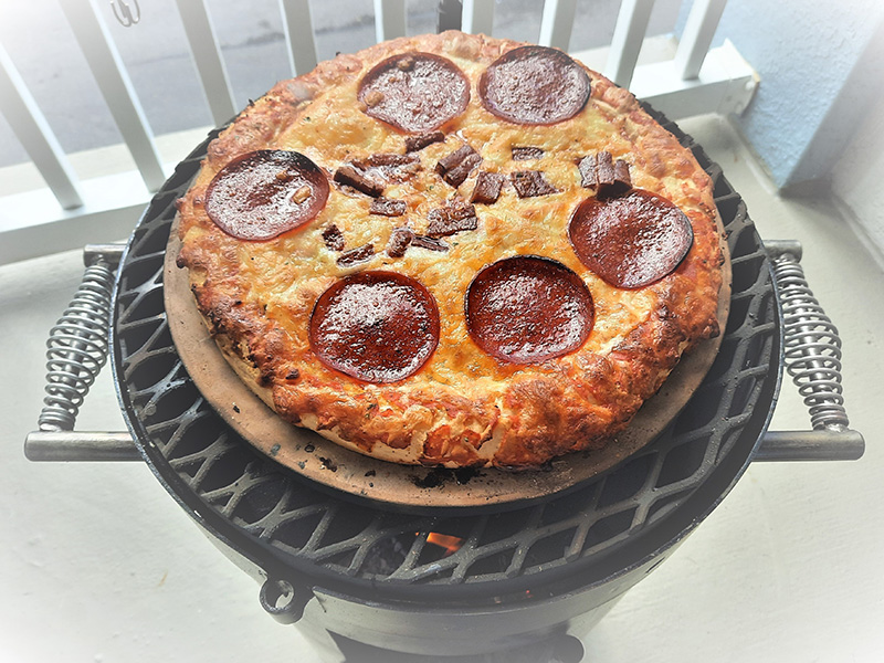 Pizza cooking on a round pizza stone cooking on a Bullet grill