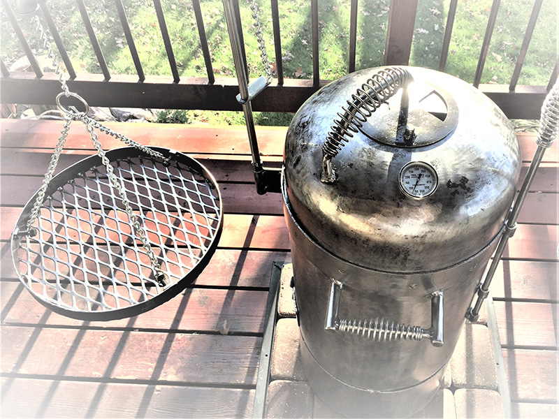 Silver Bullet grill with hanging grate on a swing arm