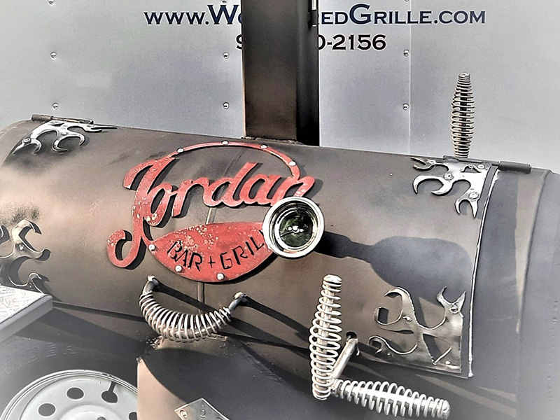 Grey T-shaped grill with red Jordan Bar & Grill artwork