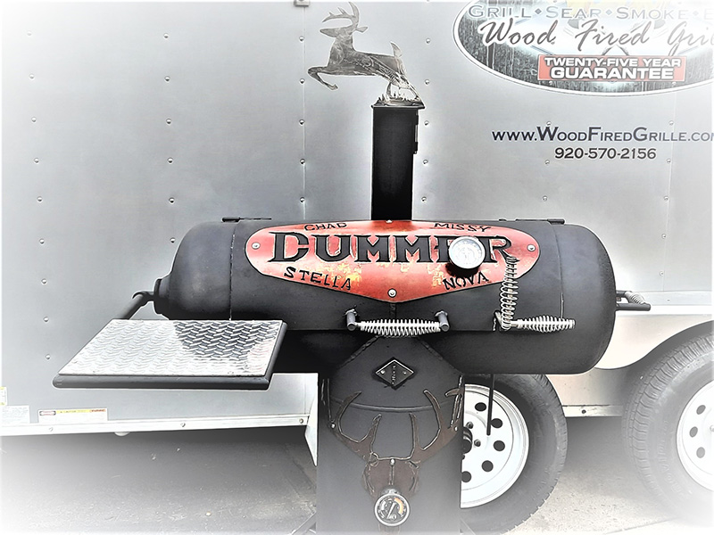 T-shaped black grill with red oval saying Dummer artwork above and black deer head with antlers below