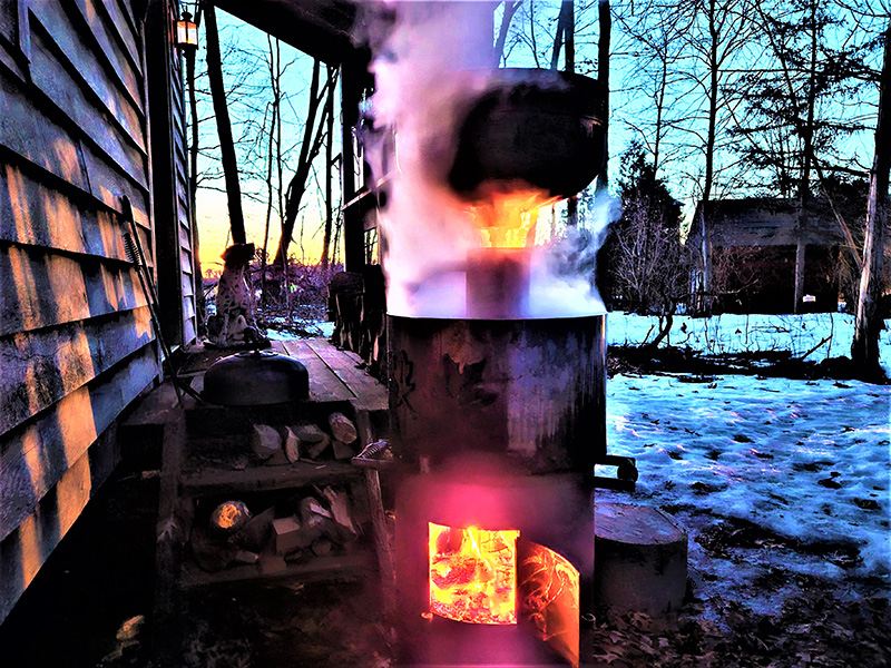 bullet-shaped black maple syrup boiler with red maple leaves artwork