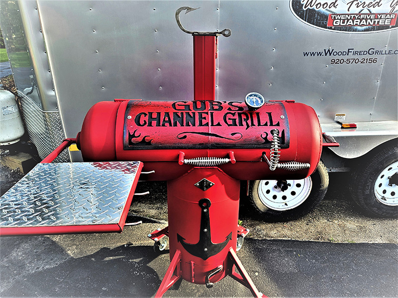 red T-shaped grill with black letters saying Gub's Channel Grill