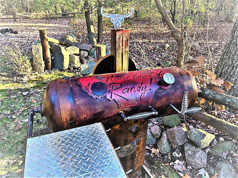 Red T-shaped grill with writing Never Forget You Randy
