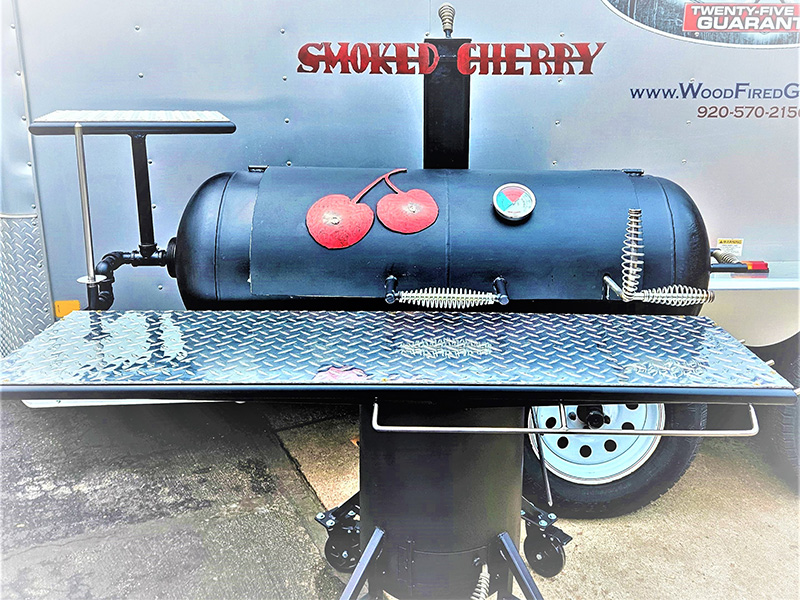 Black T-shaped grill with diamond pattern shelf. Artwork two cherries,