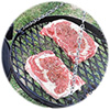 Close-up of ribeye steaks on the grill rack.