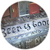 Close-up of grill cover with steel artwork saying Beer is Good written on it.